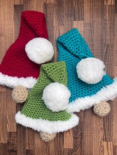 three crocheted hats with pom poms on them sitting next to each other