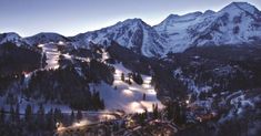 the mountains are covered in snow and lit up with lights at night, as seen from above