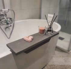 a white bath tub sitting next to a candle