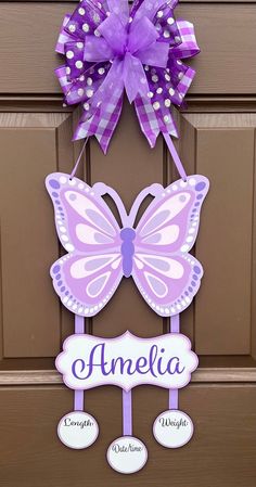 a purple and white butterfly door hanger with the name amelie on it's side