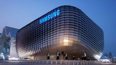 the samsung building is lit up at night with blue letters on it's side