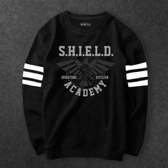 a black sweatshirt with white stripes on the sleeves and an eagle in the center that says shield