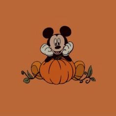 mickey mouse sitting on top of a pumpkin