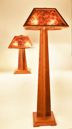 two wooden lamps are sitting on a table