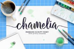 the word chamelia is written on a piece of paper next to paintbrushes and watercolor paints