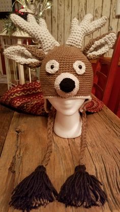 a knitted reindeer hat on top of a wooden table