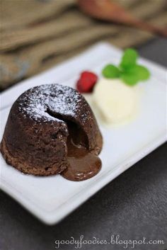 a chocolate dessert with ice cream and raspberries on a white plate, ready to be eaten