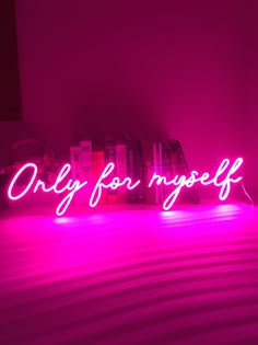 the word only for yourself is lit up in pink light on top of a bed