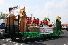 a parade float with people dressed as dogs riding in the back