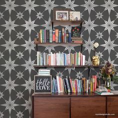 a bookshelf filled with lots of books on top of a wooden dresser next to a wall