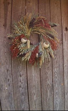 a wreath is hanging on the side of a wooden fence