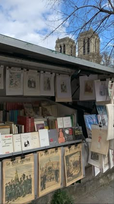 an old book stand with many books on the shelves and hanging from it's roof