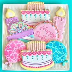 decorated birthday cookies on a white plate with blue and pink accents, including one candle