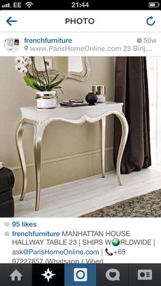 a white table with a mirror and flowers on it