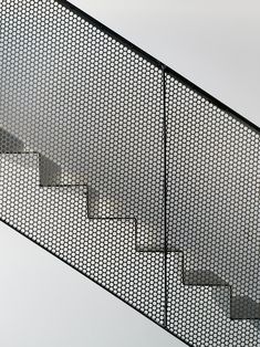 a man riding a skateboard down the side of a metal hand rail next to stairs