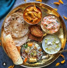 a metal plate topped with different types of food on top of a blue table cloth