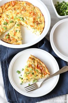 two plates with slices of quiche on them next to a fork and bowl of peas