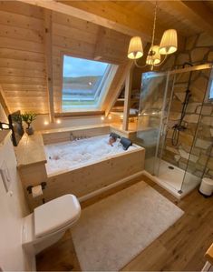 a bathroom with a tub, toilet and sink in it's corner area next to a window