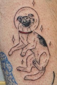 a dog with an astronaut's helmet on its back leg is shown in this tattoo