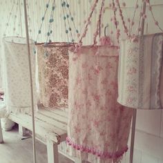 some pink and white clothes hanging from hooks on a rack next to a wooden bench