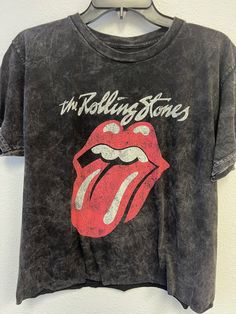 The Rolling Stones Classic Lick in Stones Oversized Crop  - 100% Cotton Fabric - Adult Oversize Crop Tee  - Black Colored tee, Mineral Wash - Available in two sizes that fit most: S/M & L/XL - Fit: the length measurements are approximate due to the process applied to the garment. - Officially Licensed The Rolling Stones apparel **We sell this product as it is shown, we do not offer custom printing services for our t-shirts as all of them are pre-printed** Dirty Cotton Scoundrels accepts returns of unworn, undamaged merchandise within 30 days of purchase for a refund.  Sorry, no exchanges are offered due to stock constantly changing. Return Address is: Dirty Cotton Scoundrels 9400 Lurline Ave Suite F Chatsworth, CA 91311 PH: 818-883-2244 Customer Service Email: dirty@goodietwosleeves.com Beast Of Burden, Rolling Stones Logo, 1960s Music, Music Tees, Road Signs, Cropped Tube Top, Rock Band, Crop Tee, Rolling Stones