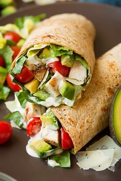 a wrap filled with chicken, lettuce and tomatoes