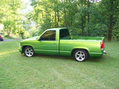 a green pick up truck parked in the grass