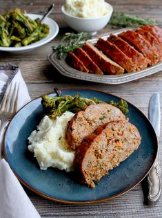 meatloaf, mashed potatoes and asparagus on a plate with silverware