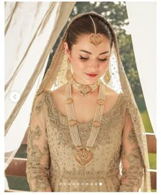 a woman in a bridal gown with jewelry on her neck and headpieces