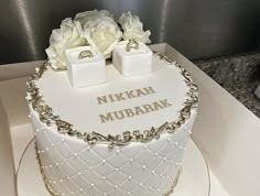 a white cake with gold trim and flowers on top