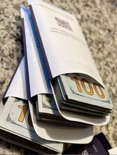 stacks of money sitting on top of each other in front of a pile of papers