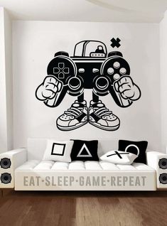 a living room with a couch and wall decal that has an image of a video game controller on it