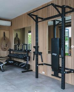 a home gym is shown in the middle of a room with mirrors and other equipment