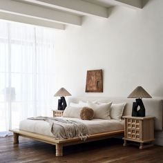 a white bed sitting on top of a wooden floor