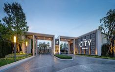 an entrance to the city hotel and conference center at dusk with trees in the background