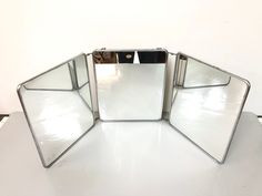 three mirrors sitting on top of a white table