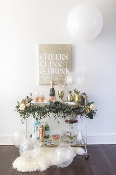 a bar cart with balloons and drinks on it in front of a sign that says cheers drink and drink