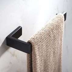 a towel hanging on the side of a white wall next to a black towel rack