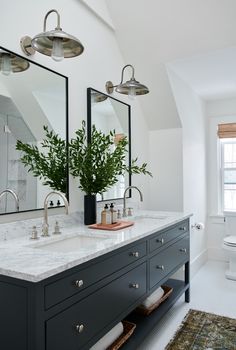 a bathroom with double sinks and two mirrors