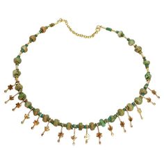 A fine Etruscan Revival style necklace. By the New York City Modernist female goldsmith Resia Schor. In 14k gold. Set with an alternating series of rough cut jade beads and stylized flower & bird gold drops on a gold wire and secured with a 14k gold safety catch. Designed with stylistic elements of the work of Resia's husband, Ilya Schor, Cubism, and Brutalism. Incorporating these elements in addition to a strong nod to the design of ancient jewelry of the Mediterranean, Resia Schor's work is st Ceremonial Gold Choker Jewelry, Traditional Green Ceremonial Choker, Ceremonial Temple Jewelry Green Choker, Vintage Gold Handmade Choker, Vintage Green Choker Necklace, Flower Bird, Rough Cut, Ancient Jewelry, Creating Jewelry