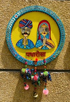 a sign on the side of a building with two women and bells hanging from it