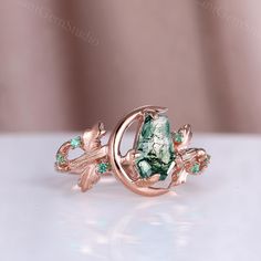 a ring with green stones and leaves on it