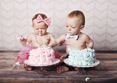 two babies sitting next to each other in front of cake