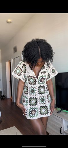 a woman with an afro standing in front of a tv