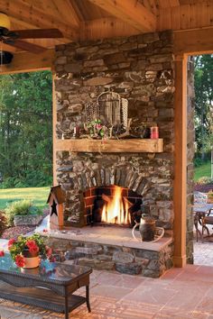 an outdoor living area with stone fireplace and patio furniture