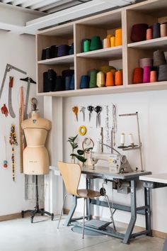 a sewing machine sitting on top of a table next to a shelf filled with different colored thread