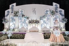 the stage is decorated with white and purple flowers