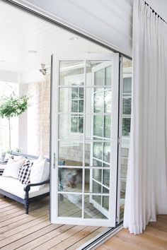 a living room with sliding glass doors and white curtains on the windowsill, outside