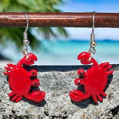 Add some fun and flair to your summer wardrobe with these handcrafted red crab polymer clay dangle earrings finished in resin. These unique earrings are the perfect accessory for adding a pop of color and whimsy to any outfit. Featuring adorable 1 inch red crabs dangling from stainless steel earwires, these earrings are lightweight and comfortable to wear all day long. The vibrant red color of the crabs is sure to stand out and make a statement wherever you go. Don't miss out on these perfect su Red Resin Novelty Earrings, Nickel-free Red Earrings For The Beach, Novelty Red Resin Jewelry, Red Resin Novelty Jewelry, Beach Dangle Jewelry In Polymer Clay, Red Polymer Clay Dangle Jewelry, Clay Crab, Crab Earrings, Red Crab