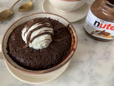 two bowls filled with chocolate pudding and ice cream on top of a marble countertop